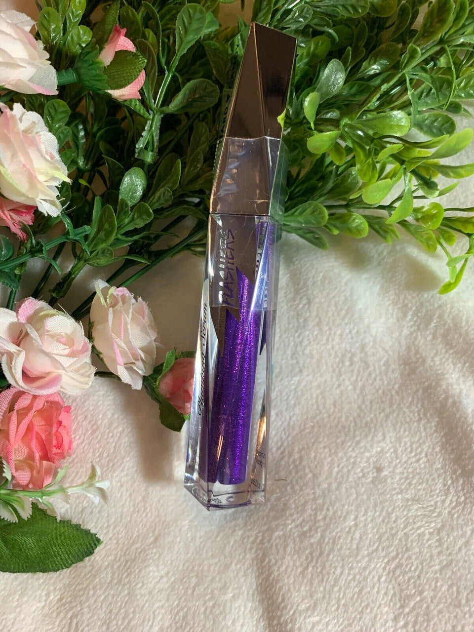 Hard Candy Dazzled #1378 lip plumping gloss in purple – sealed tube on floral background