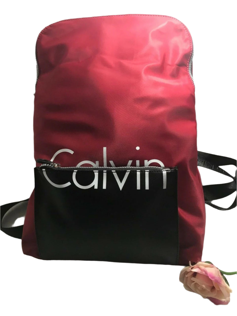 Red and black Calvin Klein backpack with large front logo, flap closure, and adjustable straps