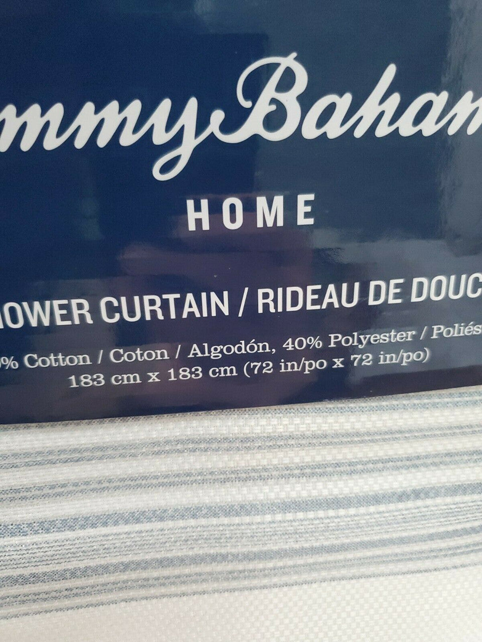 Textured blue and white striped shower curtain by Tommy Bahama folded with product label visible