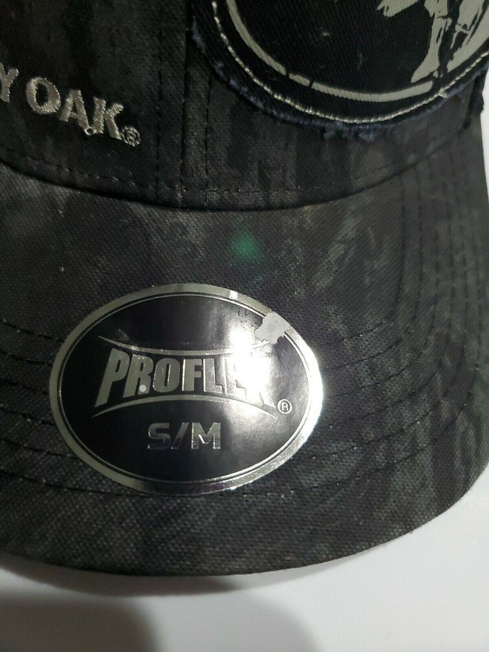 Mossy Oak men's black camo baseball cap with stretch-fit Proflex band and plastic mesh back, displayed from multiple angles.