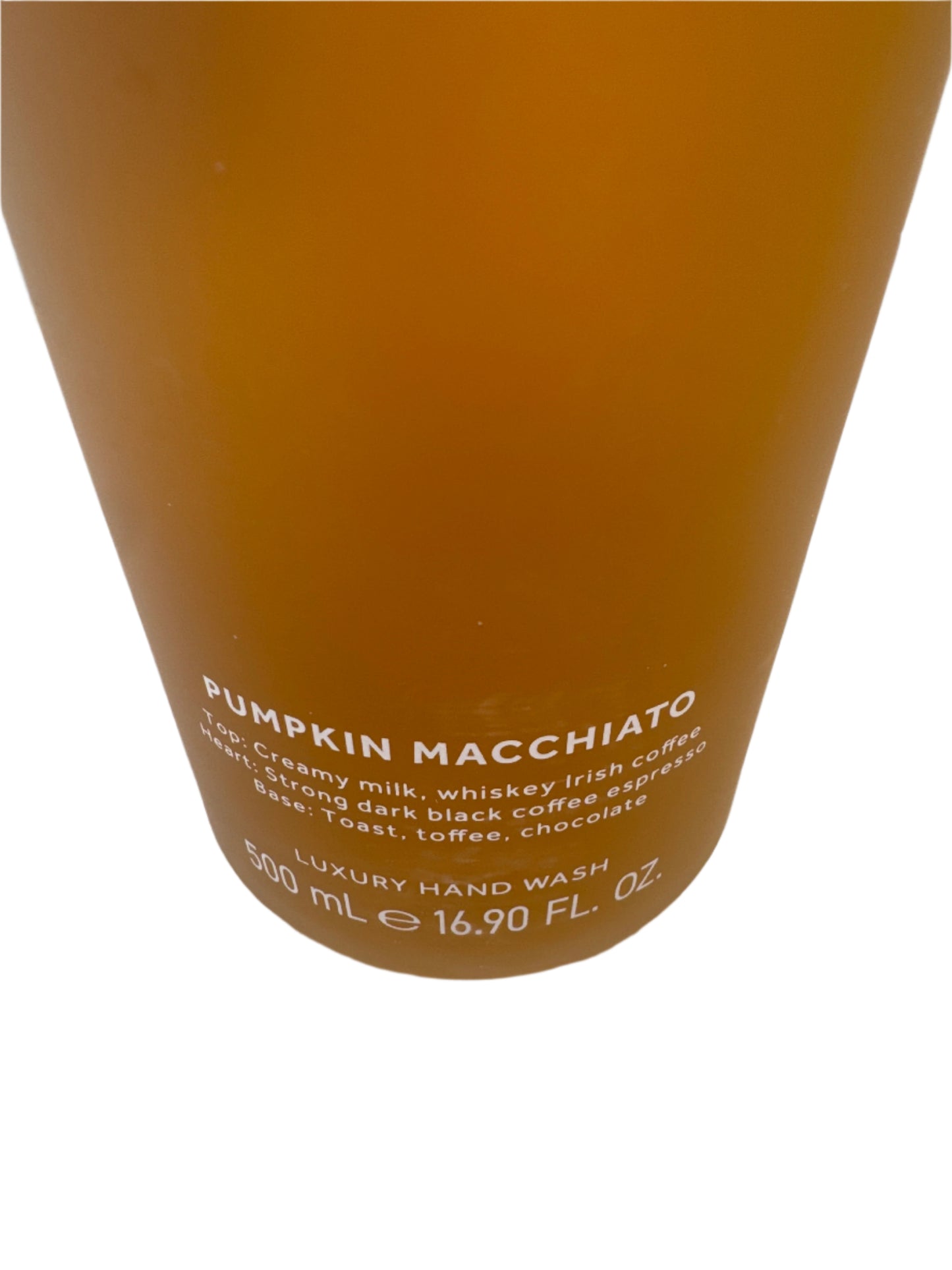 Elegant frosted glass bottle of fall-scented Pumpkin Macchiato hand soap with black pump dispenser, placed next to seasonal décor.
