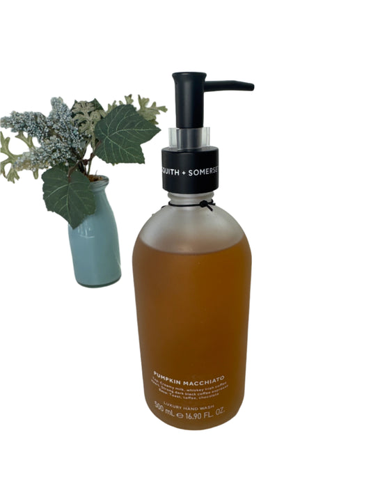 Elegant frosted glass bottle of fall-scented Pumpkin Macchiato hand soap with black pump dispenser, placed next to seasonal décor.