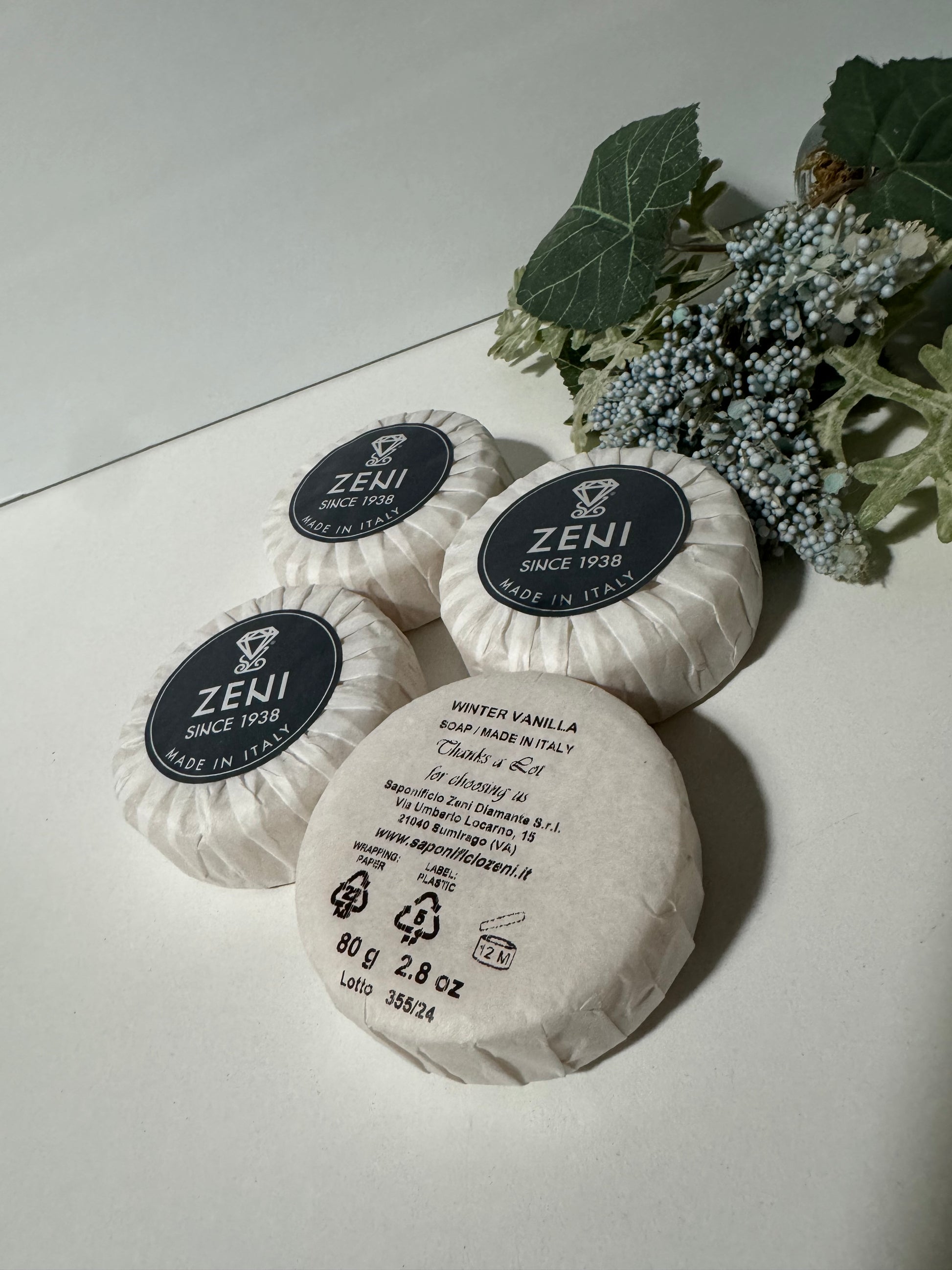 Winter Vanilla round soap bars unboxed, arranged flat with greenery, showcasing elegant packaging