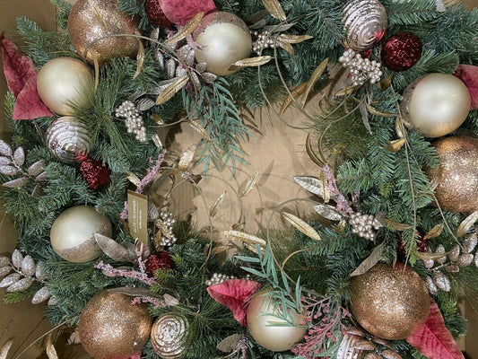 A 32 inch faux pine wreath with rose gold ornaments and glitter decorations, designed by Martha Stewart.