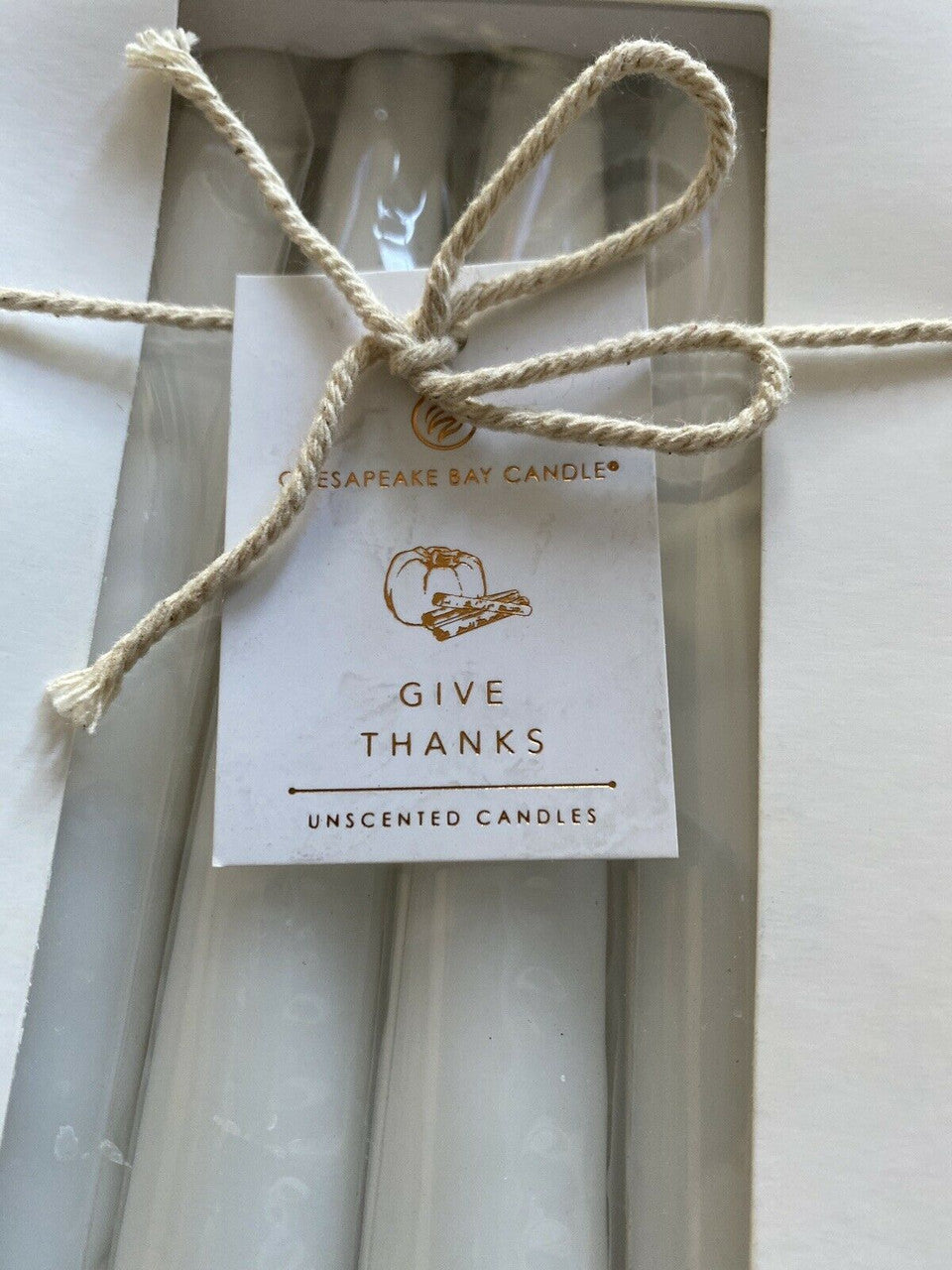 Set of 8 dripless unscented white taper candles in original packaging, ideal for elegant home decor or events