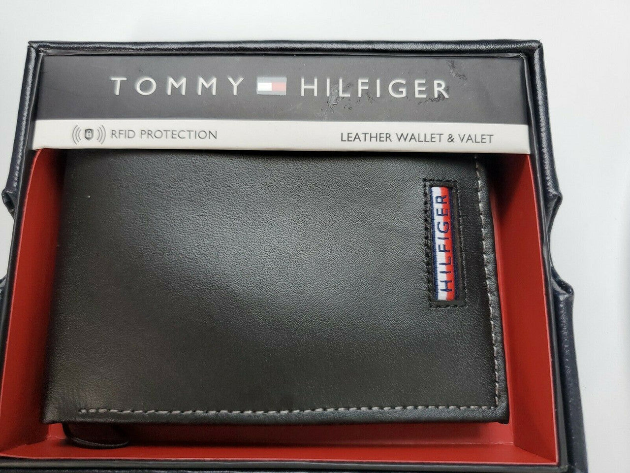 Men’s black leather bi-fold wallet with card holder by Tommy Hilfiger, shown in gift box