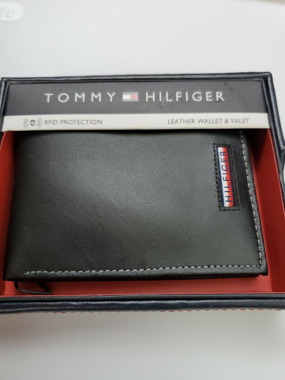 Men’s black leather bi-fold wallet with card holder by Tommy Hilfiger, shown in gift box