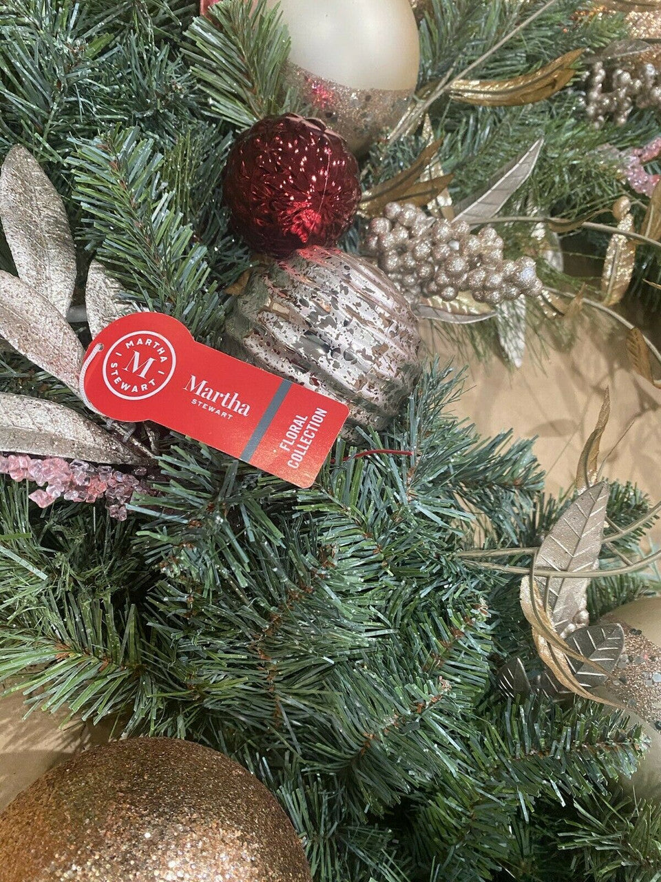 Decorative Christmas wreath with ornaments and ribbon.