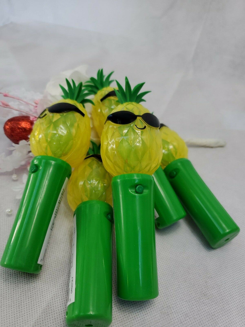 A set of five green and yellow light up spinner toys designed to look like pineapples.