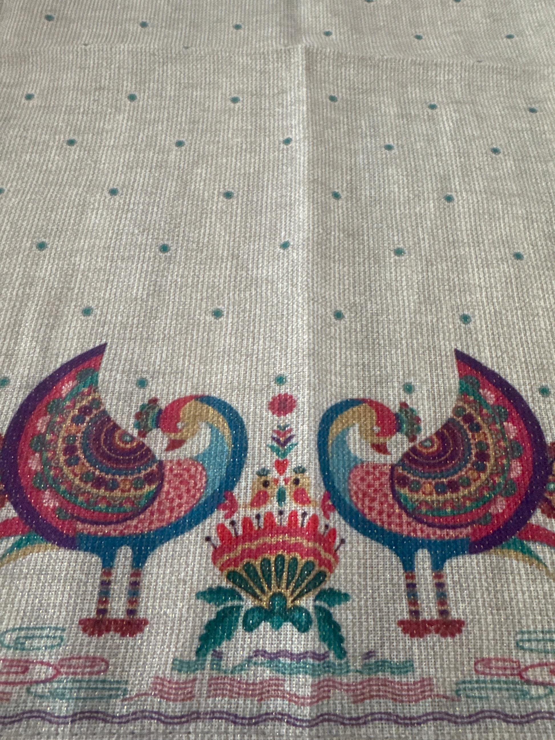 Close-up of a set of 8 vibrant, peacock-themed napkins with intricate lurex and printed designs. Each napkin is elegantly crafted from polyester with metallic fibers, showcasing a festive and luxurious touch with a rich color palette